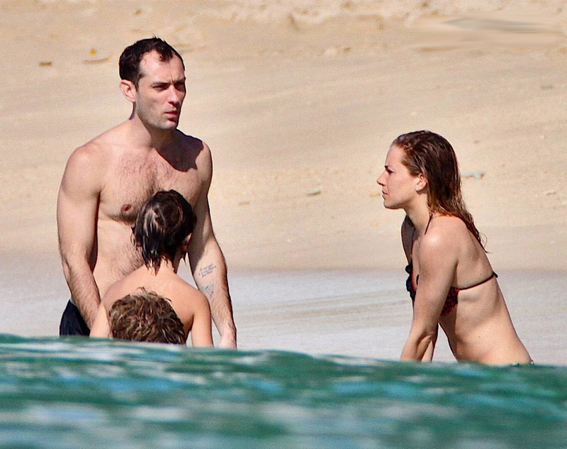 Jud Law sunbathes shirtless on the beach