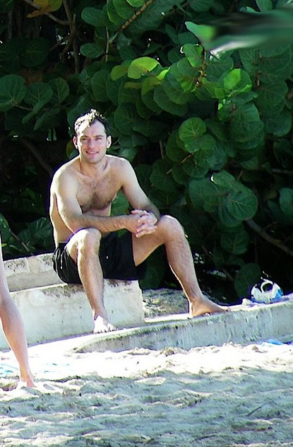 Jud Law sunbathes shirtless on the beach